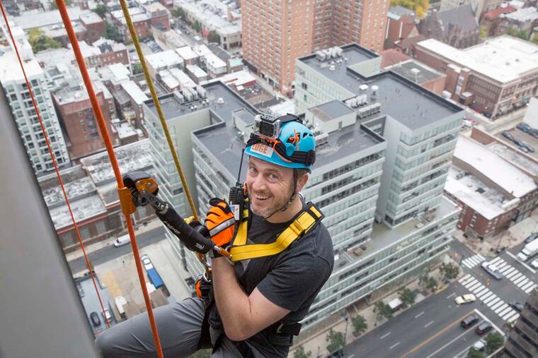 Mike Gadsby, cofounder of 03 World, a Fishtown company specializing in digital production, begins his decent down Two Commerce Square on Market Street.