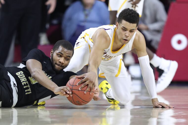 Ja'Cor Smith (left) of Neumann-Goretti and Lynn Greer III of Roman Catholic go after a loose ball.