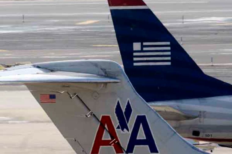 American Airlines and US Airways jets prepare for flight at gate at the Philadelphia International Airport, Thursday, Feb. 14, 2013, in Philadelphia. The merger of US Airways and American Airlines has given birth to a mega airline with more passengers than any other in the world. (AP Photo/Matt Rourke)