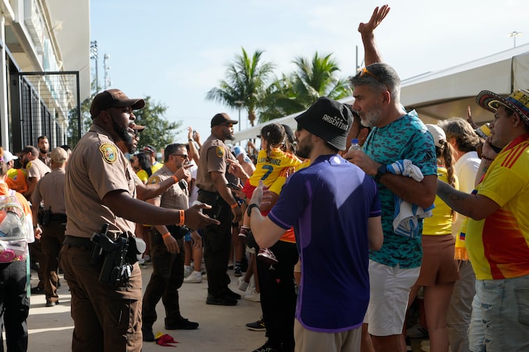Policemen talk with fans outside the stadium prior to the Copa America final soccer match between Argentina and Colombia in Miami Gardens, Fla., on Sunday, July 14, 2024.