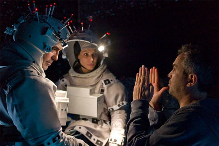 Director Alfonso Cuarón talks to actors Sandra Bullock and George Clooney during the production of "Gravity." Bullock and Clooney portray astronauts stranded in orbit around Earth.