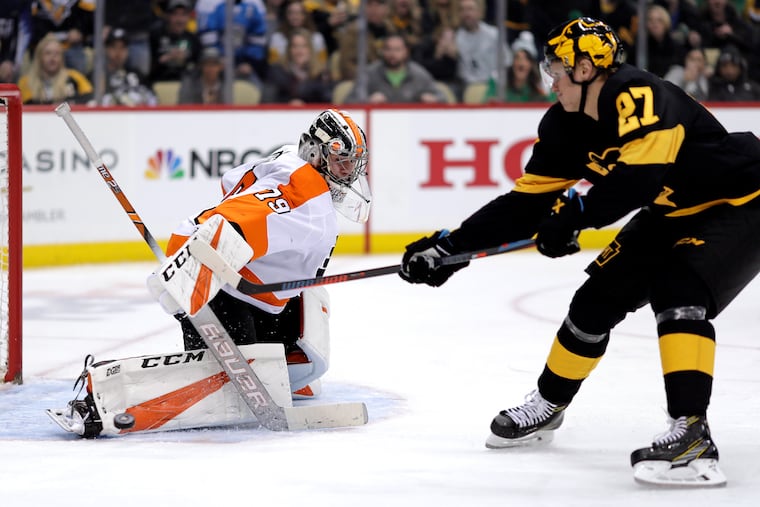 Flyers goaltender Carter Hart (left) stopping a breakaway by Nick Bjugstad late last season in Pittsburgh. Hart made 40 saves in the Flyers' 2-1 overtime win, but he has been inconsistent this season.