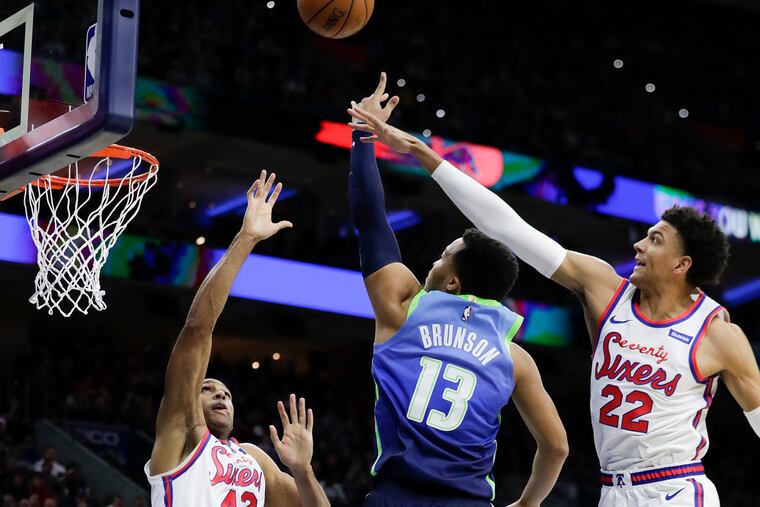 Dallas Mavericks guard Jalen Brunson, guarded by Al Horford (42) and Matisse Thybulle (22), goes in for a third-quarter layup at the Wells Fargo Center on Friday.