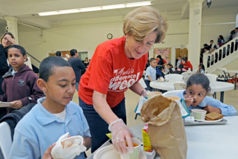 Denise Morrison serves soup to Vincent Lopez and Sienna Castro, both 9, at Holy Name School in North Camden. (April Saul / Staff Photographer)