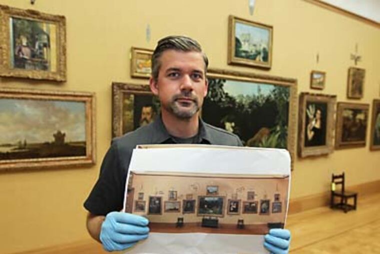 Tim Gerschick, a Barnes Museum art handler/collections assistatnt, holds his reference photo for the upstaris gallery at the new Barnes Collections Gallery in Philadelphia. Tim uses these photographs from the Merion Gallery to place the artwork back in exactly the same place position in the new galleries downtown. ( MICHAEL BRYANT / Staff Photographer )