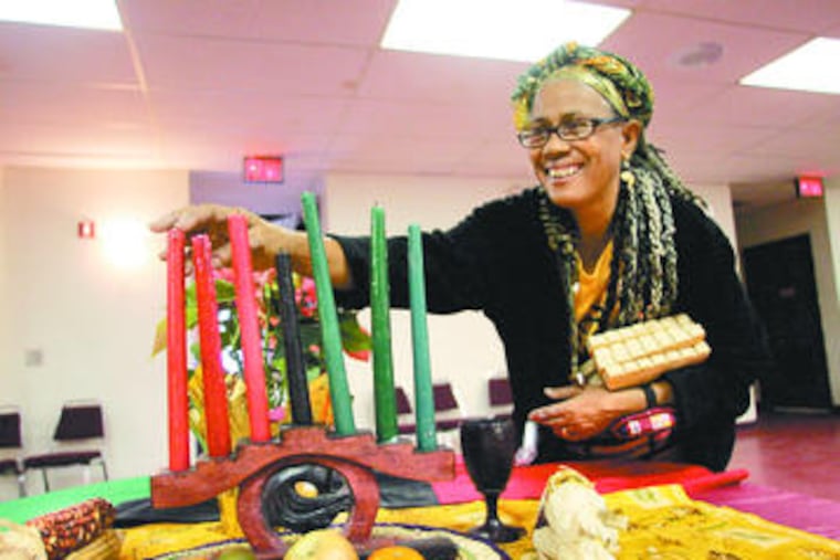 Dolores Streater-Logan adjusts candles that represent the seven Kwanzaa principles.