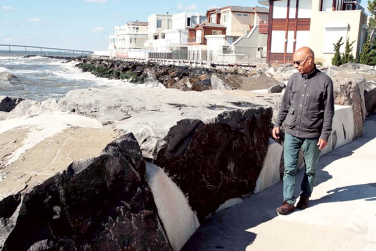Longport's mayor, Nick Russo, walks on 11th Street in Longport with houses reconstructed after being damaged by Hurricane Sandy in the background.