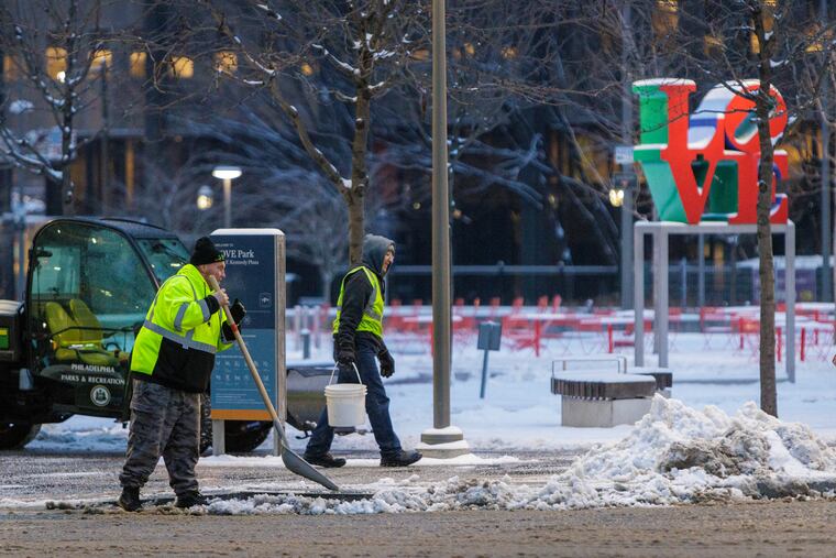 Parks and Recreation employees removing snow from around LOVE Park on Tuesday morning. They may be back out there Friday.
