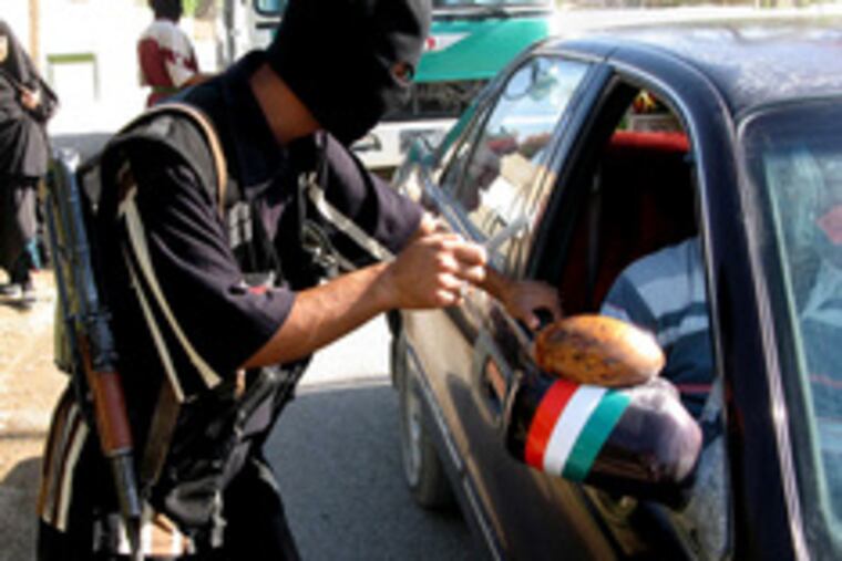 Having been tipped off about a possible al-Qaeda attack, an armed man checks cars coming into Buhriz, 35 miles north of Baghdad. Bombings around Iraq claimed at least 46 lives yesterday.