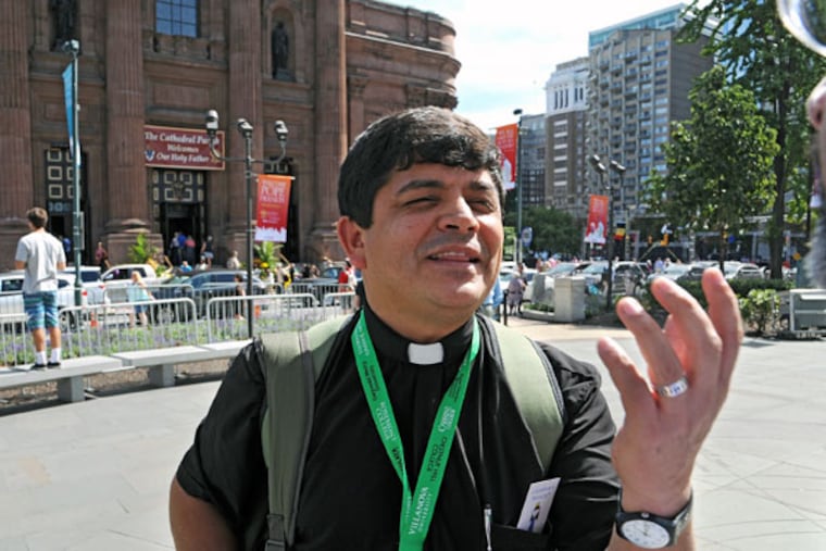 William Villa, a Spanish-speaking priest from Colombia who serves a parish in Jacksonville, Fla., strolled the parkway on Thursday, taking in the scene. He was surprised by the city's architecture and its residents. (CLEM MURRAY/Staff Photographer)