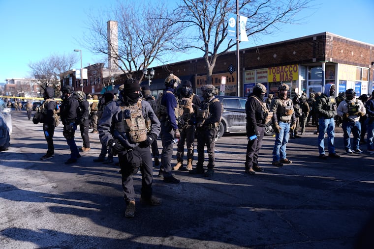 Federal agents stand near the site of a shooting Saturday, Jan. 24, 2026, in Minneapolis.