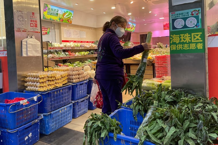 A woman shops in a reopened grocery store in the district of Haizhu as pandemic restrictions are eased in southern China's Guangzhou province on Thursday.