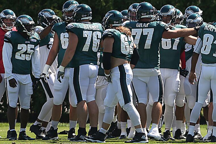 Eagles players huddle before practice. (David Maialetti/Staff Photographer)