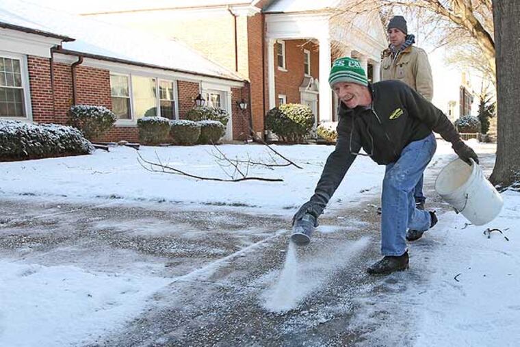 Chris McArdle, of McCardle Landscaping, looks like he is bowling in February 2013 as he spreads salt on the sidewalk of the First United Methodist Church of Media, Pa. (Michael Bryant / Staff Photographer)