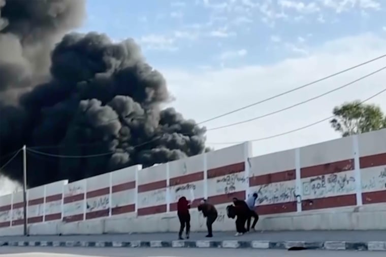This image made from ITV News video shows a group of five men trying to take cover while walking down a street west of the southern city of Khan Younis in Gaza. Earlier, they could be seen holding their hands in the air and one waved a white flag.