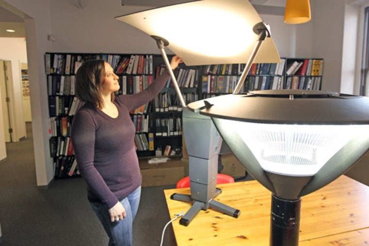 Heather Kilroy, a project manager at the Lighting Practice, adjusts a reflector in a comparison test. (Michael Bryant / Staff Photographer)