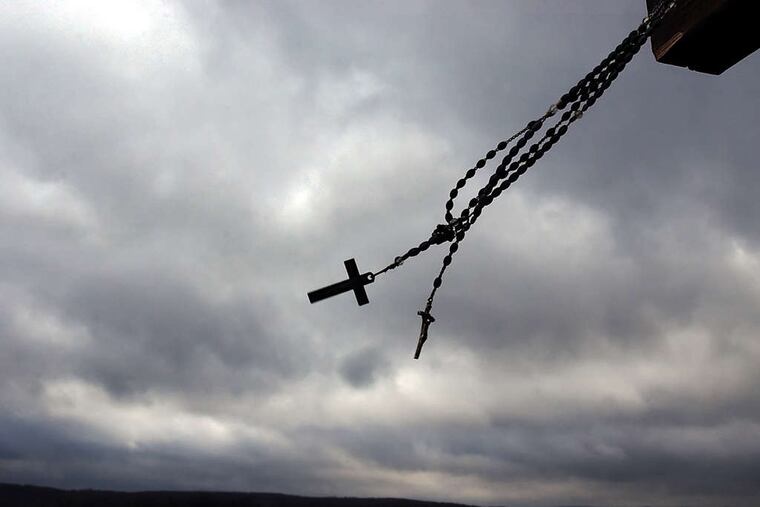At the crash site of Flight 93 in Shanksville, rosary beads and a crucifix swing in the cold wind in December 2001.
