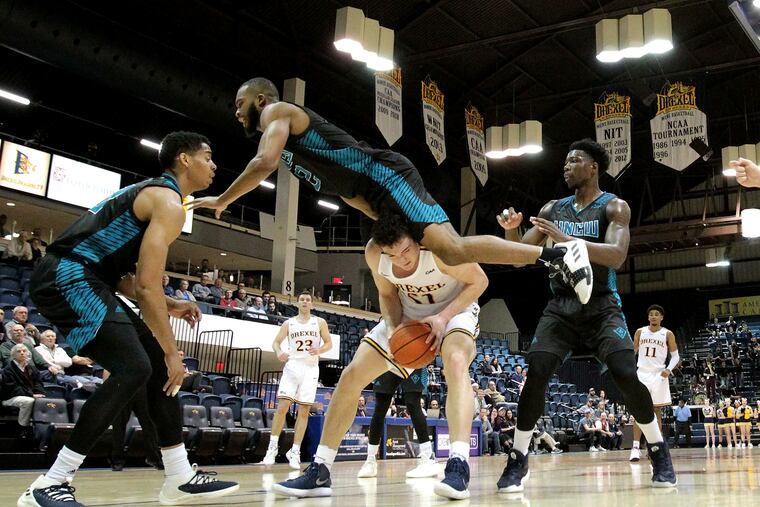 Jeantal Cylla, top center, of UNC Wilmington goes flying over James Butler of Drexel after being faked off the court in the 2nd half on Feb. 7, 2019.