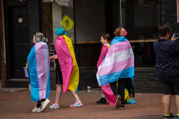 Young people walk the streets of Phoenixville draped in different pride flags during the Chester County PrideFest in 2022. The county is set to vote on a nondiscrimination ordinance next week after years of advocacy.