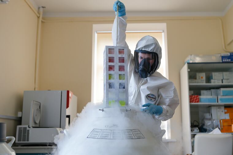 In this Aug. 6 photo provided by Russian Direct Investment Fund, an employee works with a coronavirus vaccine at the Nikolai Gamaleya National Center of Epidemiology and Microbiology in Moscow.
