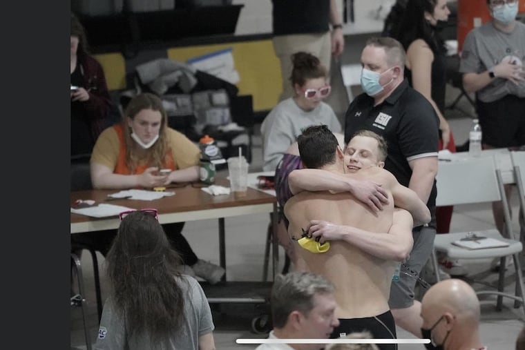 Logan Brockway embraces Stephen Dow (facing camera) after Dow won the 200-yard breaststroke at the PSAC Championships.