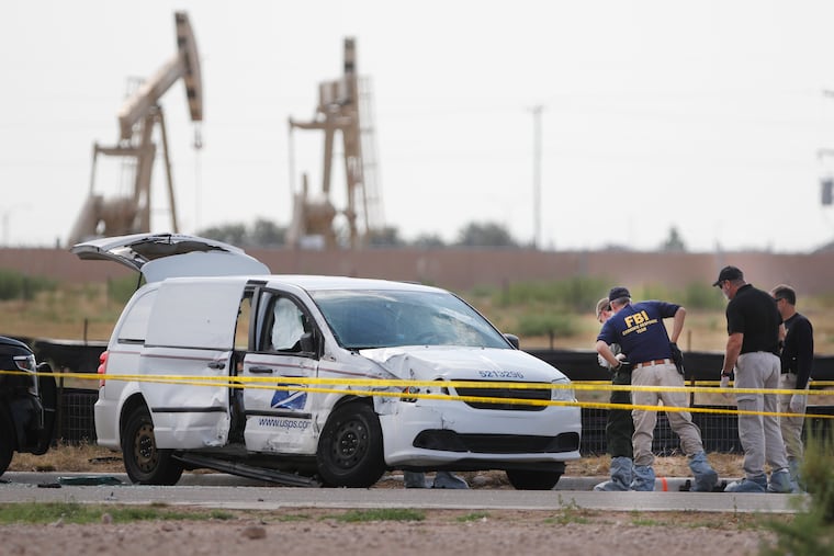 Authorities look at a U.S. Mail vehicle, which was involved in Saturday's shooting, outside the Cinergy entertainment center Sunday, Sept. 1, 2019, in Odessa, Texas. (Mark Rogers/Odessa American via AP)