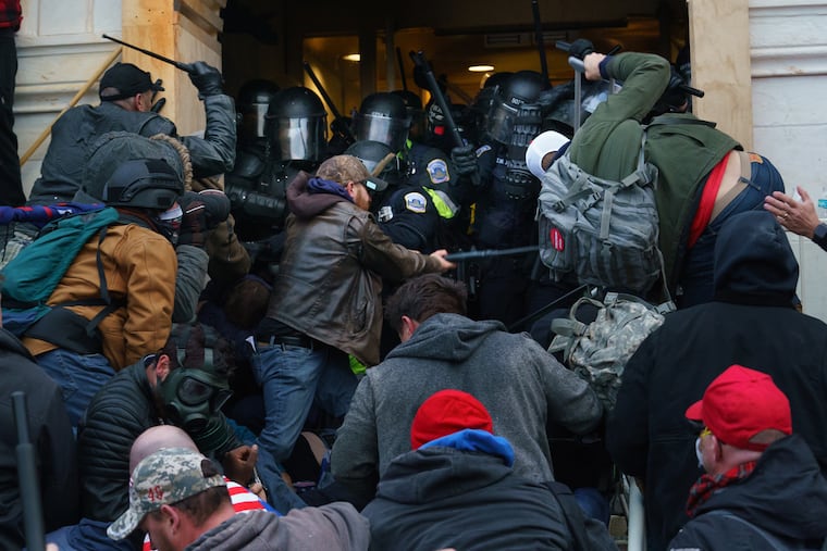 Rioters clash with police to try and gain entrance to a door at the Capitol building on Jan. 6, 2021, in Washington, D.C.