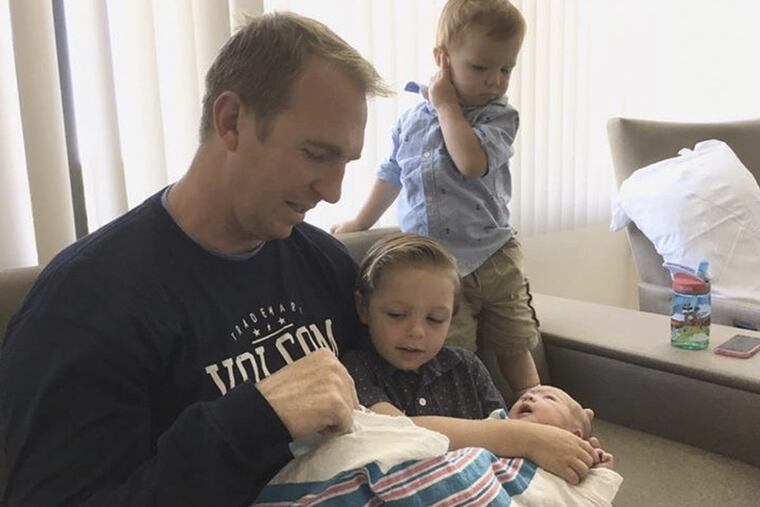 CBS3 reporter Cleve Bryan holds daughter Lucia Victoria as sons Joshua (L) and Colton (r) watch.