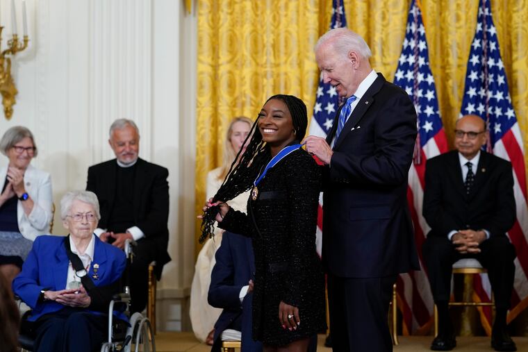 President Joe Biden awards the nation's highest civilian honor, the Presidential Medal of Freedom, to gymnast Simone Biles during a ceremony in the East Room of the White House. Biles is the most decorated U.S. gymnast in history, winning 32 Olympic and World Championship medals, and is an advocate on issues including athletes' mental health, children in foster care and sexual assault victims.