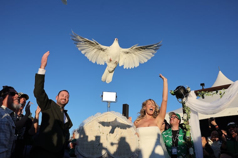 Brandon and Lindsey Bryd celebrate during a dove release after they were married at the Garage Beer “ultimate Philly tailgate wedding".
