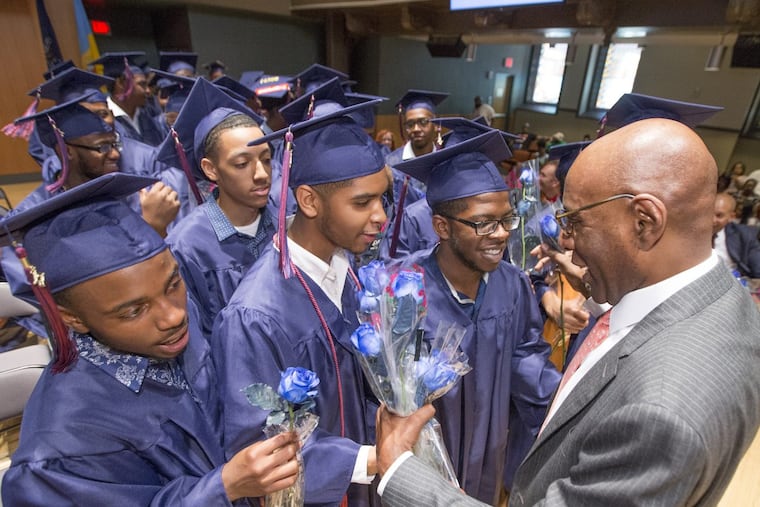 Founder and CEO David Hardy is presented roses by members of the graduating class during the Boys’ Latin graduation ceremony on June 13.