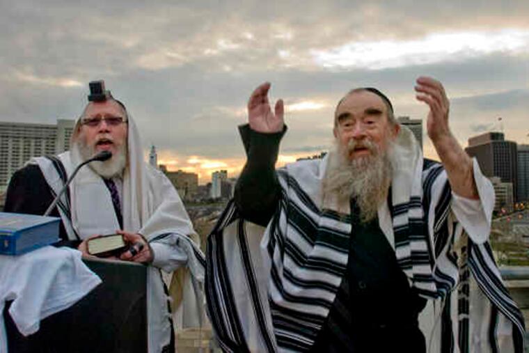 Atop the Franklin Institute, Cantor Hershel Weitz (left) and Rabbi Abraham Shemtov greet the sun in what they believe is its original position.