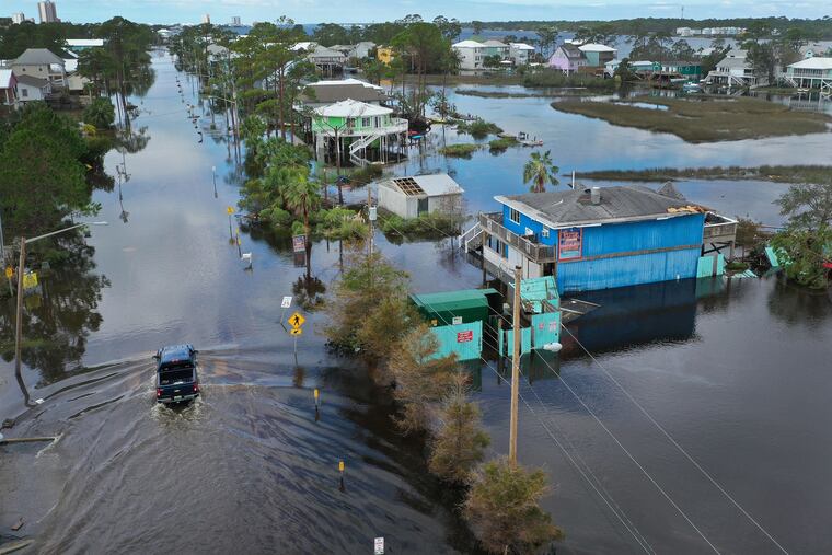 An aerial view from a drone shows a vehicle driving through a flooded street after Hurricane Sally passed through the Gulf region last month. Delta also could threaten the Gulf Coast.
