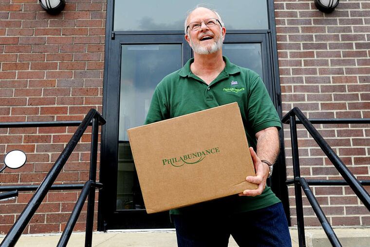 Bill Clark carrying a box in 2011 filled with food for a disabled senior living on $14,000 or less. Clark is ending his controversial tenure with Philabundance.