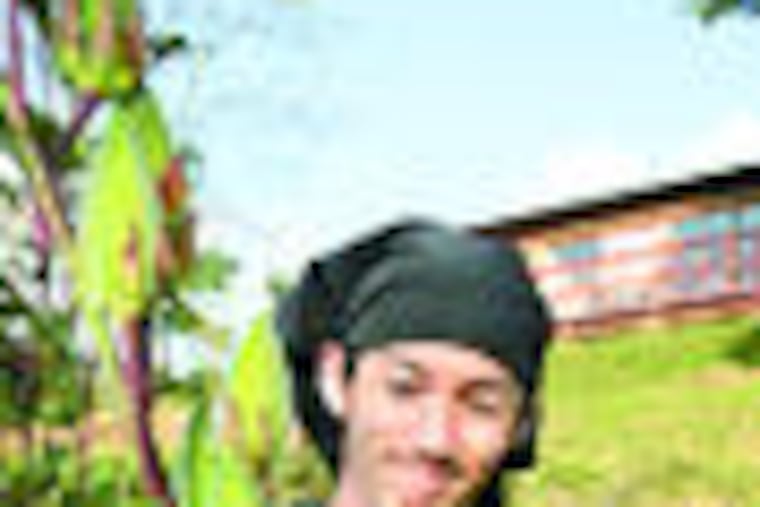 Masayuki Miura with okra seed pods in the yard in front of his restaurant where he serves 100 percent made-in-Japan dishes in Nara.