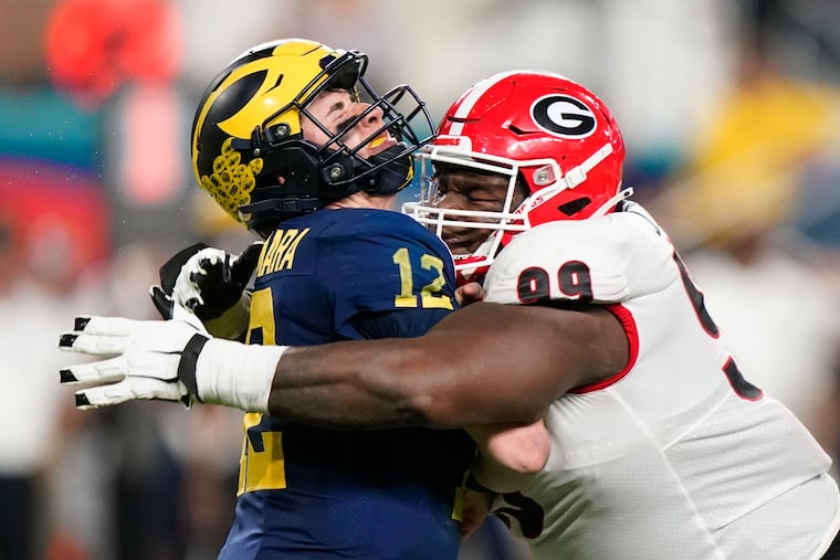 Georgia defensive lineman Jordan Davis hits Michigan quarterback Cade McNamara during the second half of the Orange Bowl NCAA College Football Playoff semifinal game, Friday, Dec. 31, 2021, in Miami Gardens, Fla. (AP Photo/Lynne Sladky)