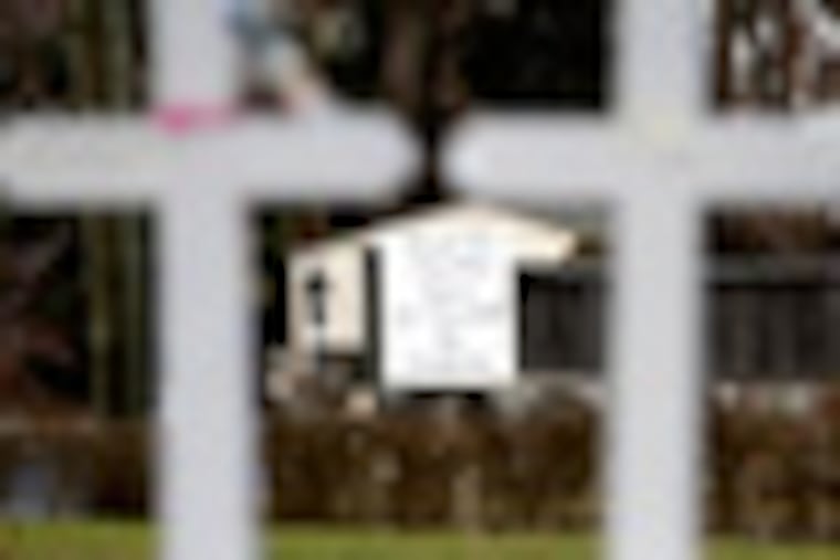 A large sign is displayed across the street from crosses bearing the names of the Newtown shooting victims in the Sandy Hook village of Newtown, Conn., Saturday, Dec. 22, 2012. The funerals for the victims of the school shooting are wrapping up after a wrenching week of farewells. Twenty children and six adults were killed at Sandy Hook Elementary School on Dec. 14. Adam Lanza, the lone gunman, killed his mother before going on the rampage and then committed suicide. (AP Photo/Seth Wenig)