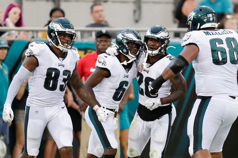 Eagles wide receiver Greg Ward (second from left) celebrates his second-quarter touchdown pass with teammates tight end Josh Perkins (left), running back Miles Sanders (second right) and offensive tackle Jordan Mailata (right).