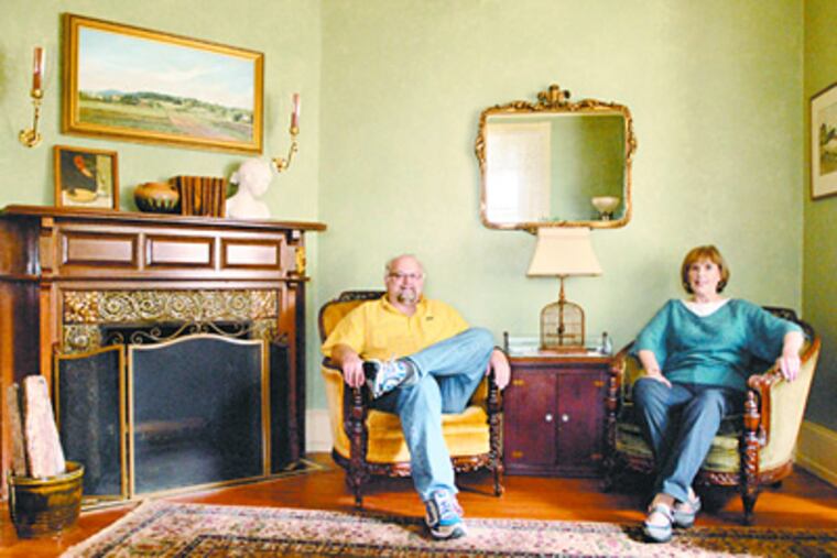 Dean Hartung and Ellen Hutchinson in the living room of their 1889-vintage home in Mount Airy. Found household items and furnishings fill their rooms not only with singular pieces, but with stories of discovery. (Ron Tarver / Staff Photographer)