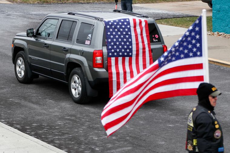 FILE: A vehicle carrying family members of U.S. Air Force Staff Sgt. Dylan J. Elchin arrives past a corridor of flags provided by members of the Patriot Guard Riders for his memorial service on Thursday, Dec. 6, 2018, in Moon Township, Pa. Elchin was one of three servicemen killed last month when their vehicle was destroyed by an improvised explosive device in Andar, Ghazni Province. (AP Photo/Keith Srakocic)