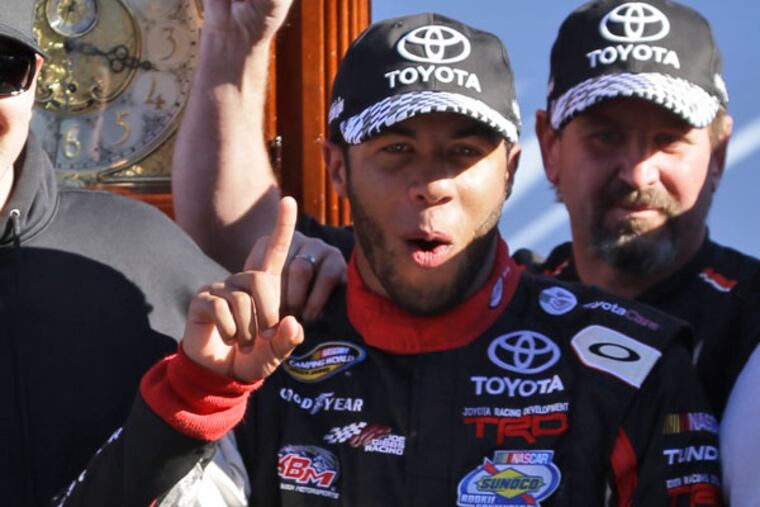 Darrell Wallace Jr., second from right, celebrates in Victory Lane with team owner Kyle Busch, second from left and Busch's wife Samantha, after winning the NASCAR Truck Series truck race at Martinsville Speedway in Martinsville, Va., Saturday, Oct. 26, 2013. The grandfather clock trophy is in the background. (Steve Helber/AP)