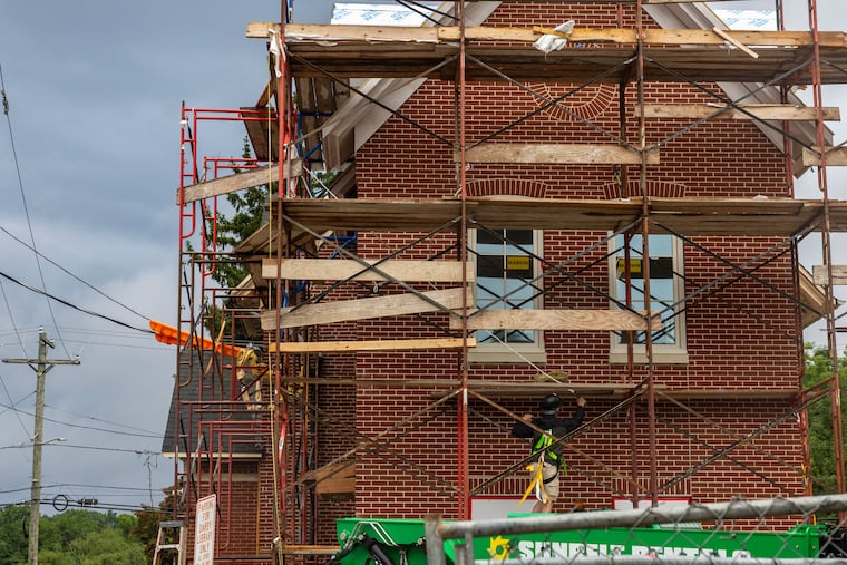 The exterior of the Darby Free Library as a construction worker works on the building's scaffolding in July. Small businesses, including those in construction and contracting, are increasingly using AI tools to make their work more efficient.