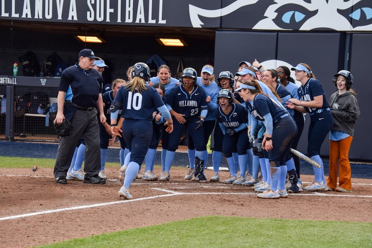 Shortstop Ava Franz receives a team welcome at the plate as she scores a run for the Villanova Wildcats.