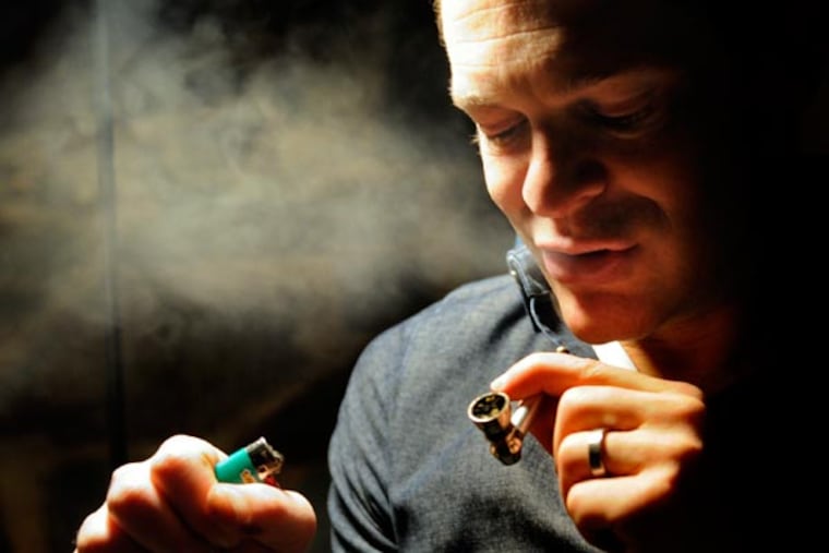 Jay Lassiter takes his first ever legal toke of medical marijuana at his home in Cherry Hill December 18, 2012. With a license to use medical marijuana to ease the side effects of his HIV medications, he had just made the the two hour drive home from Greenleaf Compassion Center in Montclair, NJ's only medical marijuana dispensary, where he picked up a legal bag of 3/4 ounces of medical marijuana. ( TOM GRALISH / Staff Photographer )