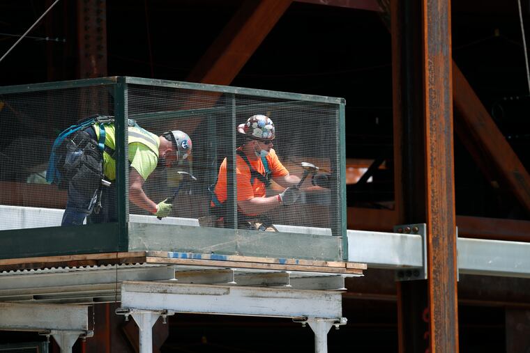 Workers build a protective railing as construction continued on the New York Islanders' new arena, located adjacent to Belmont race track, Wednesday, May 27, 2020, in Elmont, N.Y. Long Island became the latest region of New York to begin easing restrictions put in place to curb the spread of the coronavirus as it enters the first phase of the state's four-step reopening process. Gov. Andrew Cuomo announced Tuesday that Nassau and Suffolk Counties could begin reopening parts of their economy after nonessential businesses were shuttered for two months. (AP Photo/Kathy Willens)