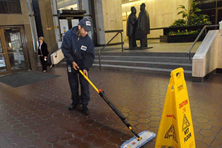Alphonso Thompson tends to the lobby floor of the Glaxo- SmithKline building.(April Saul/Staff)