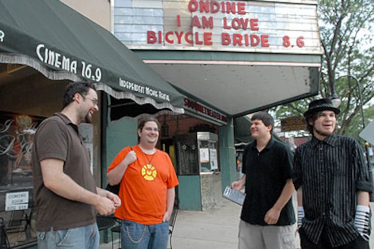 At the Cinema 16:9 in Lansdowne, Terrible Tuesday, the one night a week that theater owner David Titus shows film fans a truly bad movie. Here, Titus, left, in front of the theater with Geoff Miller of Sharon Hill who also works at the theater; John Yates of Lansdowne; and John's brother, Jeffry Yates. (April Saul / Staff Photographer)