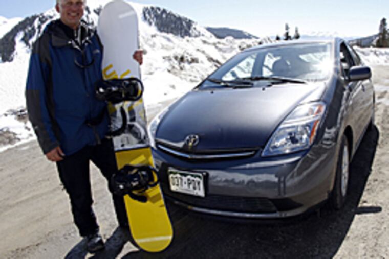 Kim Fenske, of Copper Mountain, Colo., poses for a photo beside his 2008 Toyota Prius sedan before he sets out for a day in the snow in Colorado. (AP)