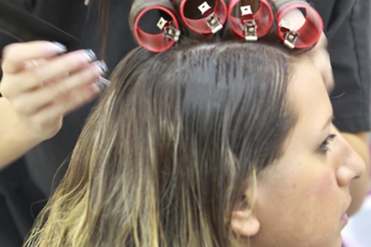 Danielle Linke, 18, of Hamilton, works on her sister Jennifer Linke. (Akira Suwa / Staff Photographer)