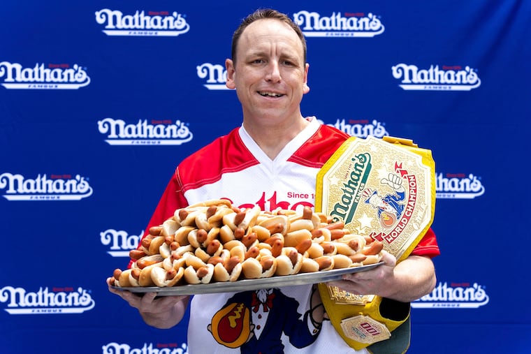 Competitive eater Joey Chestnut poses for photos with 76 hot dogs at a weigh-in before the Nathan's Famous July Fourth hot dog eating contest on Friday, July 1, 2022, in New York.